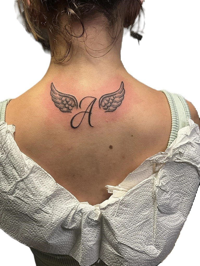 tatouage de la lettre a entourée d'ailes