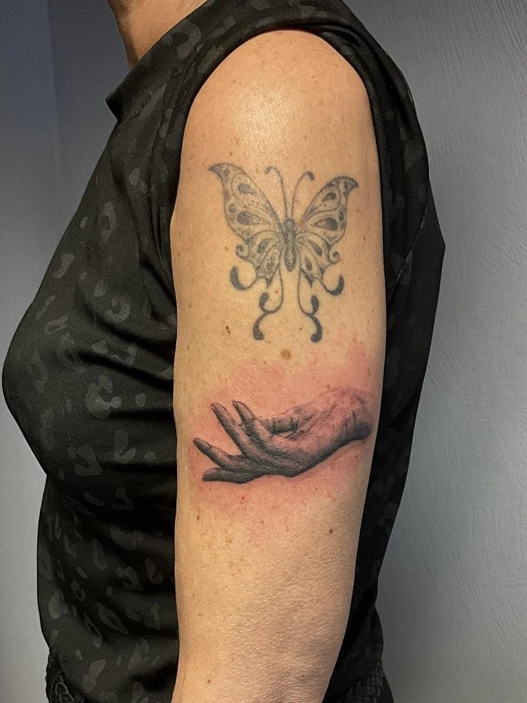 tatouage dune main comme soutenant un papillon