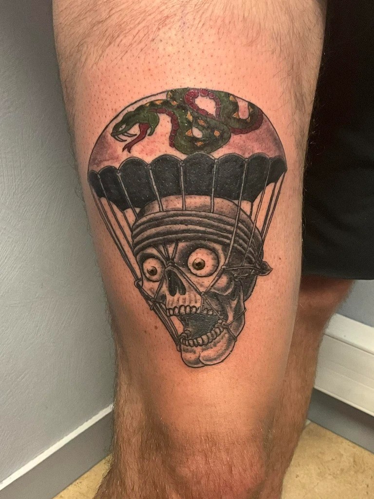 tattoo à l'ancienne d'un crane avec parachute et serpent